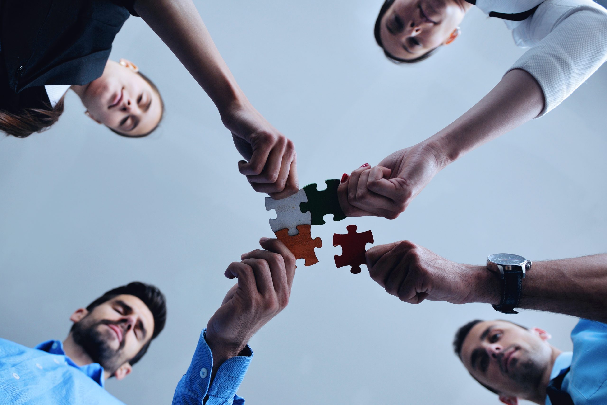 Group of business people assembling jigsaw puzzle